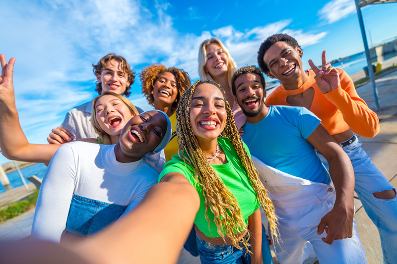 Multi-ethnic friends taking a selfie and smiling in the city in a sunny day of summer