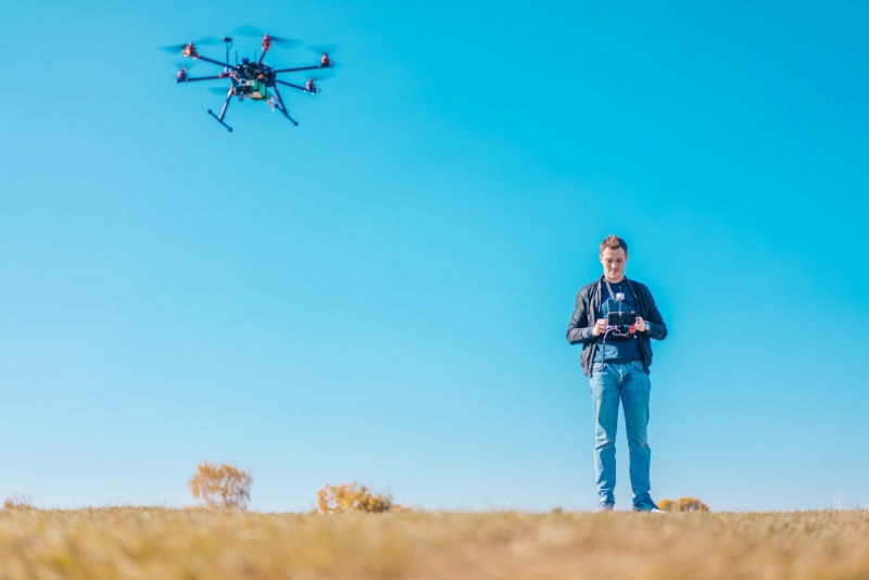Young european man navigating drone by remote controller